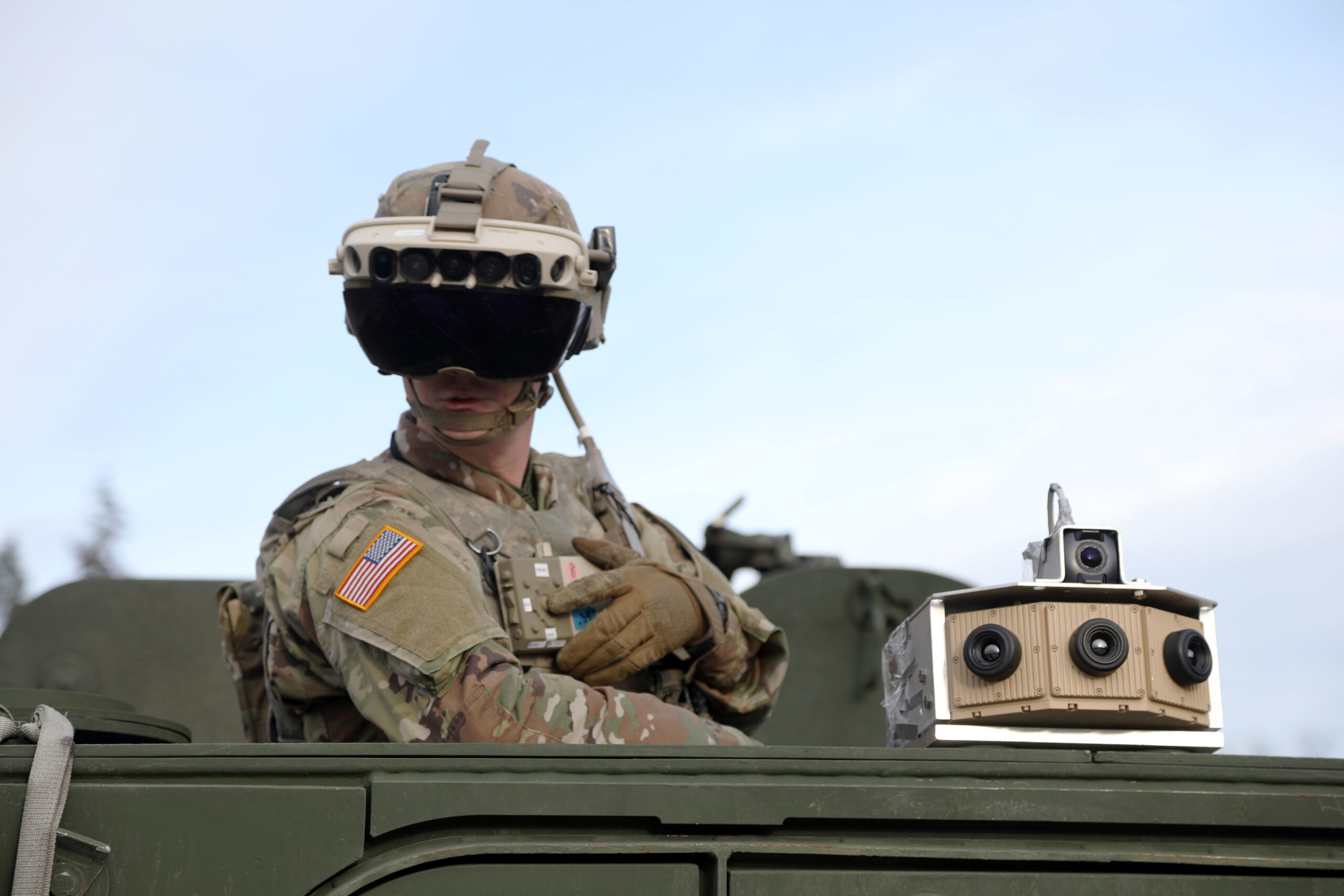 A U.S. Army soldier uses the Integrated Visual Augmentation System (IVAS) mixed-reality headset mounted on a Stryker vehicle. U.S. Army photo by Courtney Bacon (public domain).